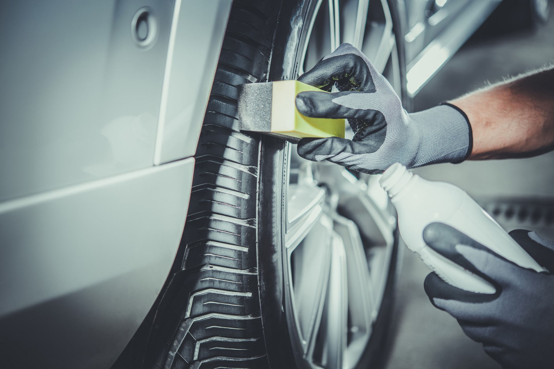 Car Detailing Worker Taking Care of Vehicle Tires and Alloy Wheels